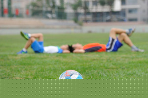 kids laying down in a soccer field