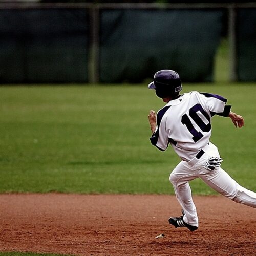 Young Baseball Athlete in Uniform Running for Home Base