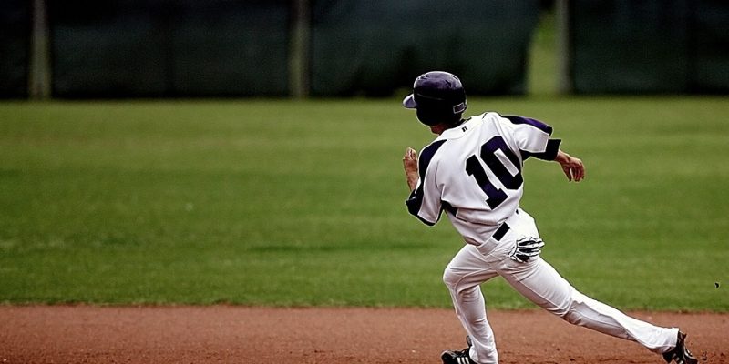 Young Baseball Athlete in Uniform Running for Home Base