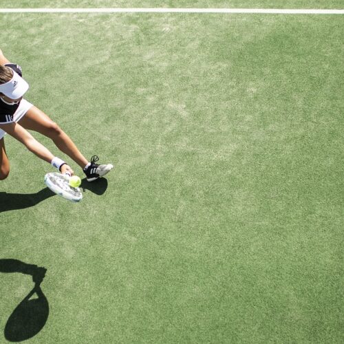 Teenager playing tennis on green court